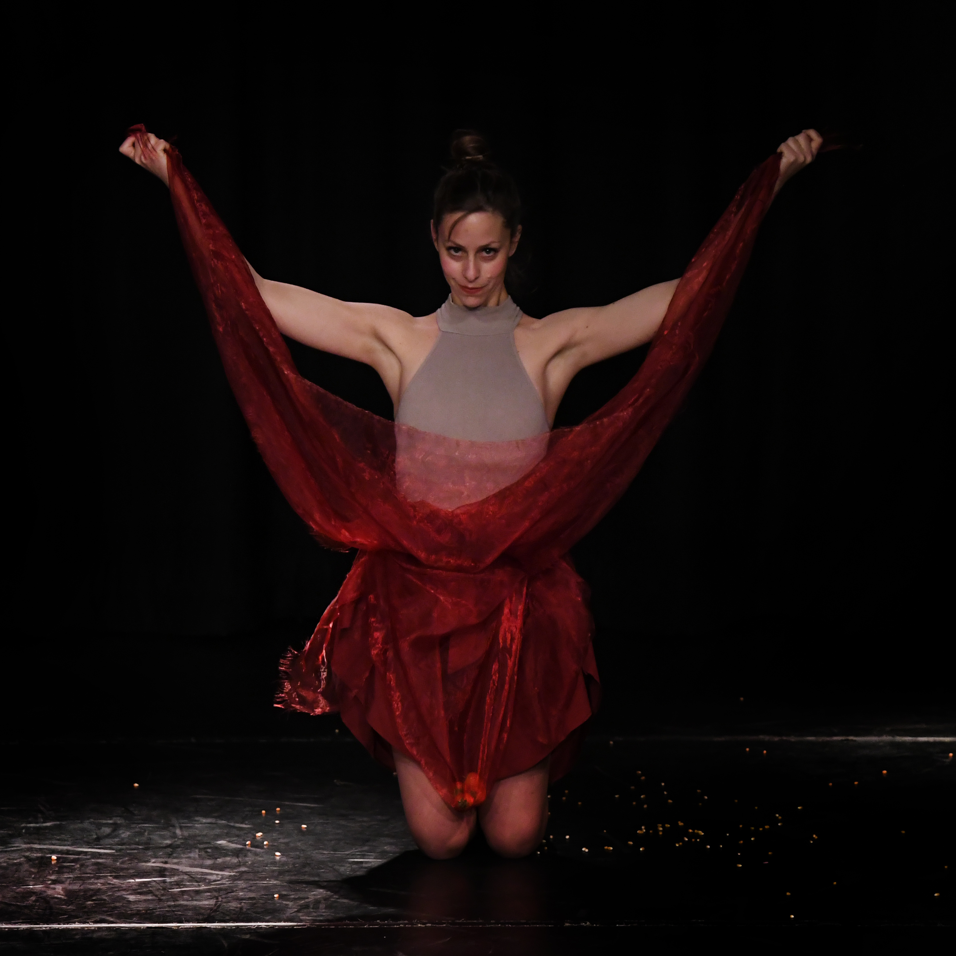 A dancer posts with a red cloak.